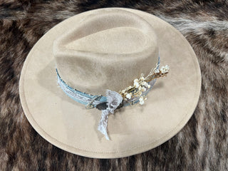 Tan felt flat brim western hat with pinched crown and custom denim band with dried florals, angled top view