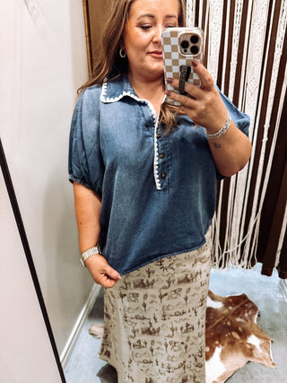 Close up of scalloped crochet trim on denim blouse neckline