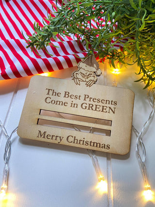 Empty wooden Christmas money holder showing the slots for rolled bills