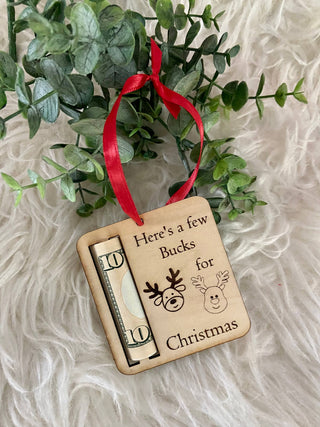 Wooden reindeer Christmas ornament that holds a rolled bill, styled on white fur with greenery