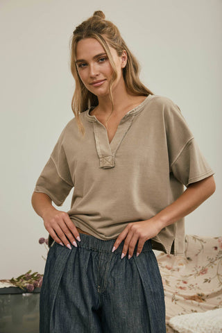 Close-up of raw edge hem and exposed seam on mocha knit top