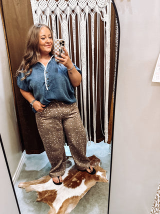 Woman wearing denim popover blouse with crochet trim v-neck