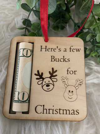 Close-up of the engraved reindeer Here's a Few Bucks for Christmas ornament with a rolled bill