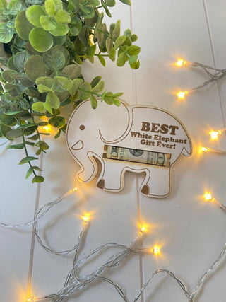Laser engraved elephant gift swap money holder holding a rolled bill with greenery