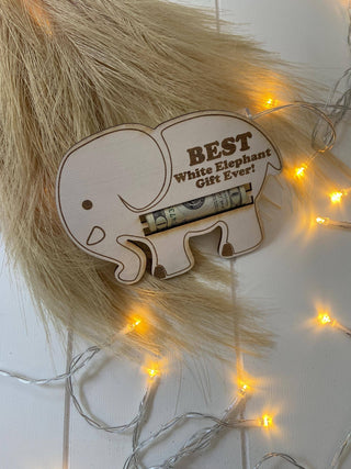 Wooden elephant money holder with a rolled bill on a tan fur backdrop