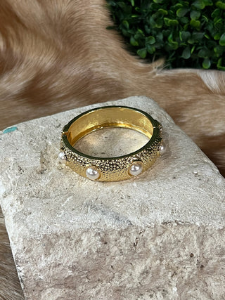 Hammered gold-tone hinged bangle bracelet with round stone cabochons