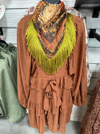 Deer print fringed scarf worn as a neckerchief over a rust tiered ruffle long sleeve dress