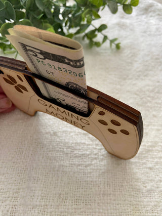 Side view of the Gaming Money wooden controller money holder held in hand with a bill