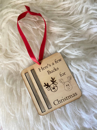 Empty wooden Bucks for Christmas money holder ornament with red ribbon showing the bill slot