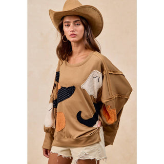 Oversized Halloween patchwork sweatshirt, close-up of pumpkin and witch boot appliqué